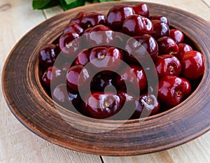 Ripe black cherries in a clay bowl