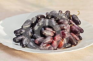Ripe black grapes on white