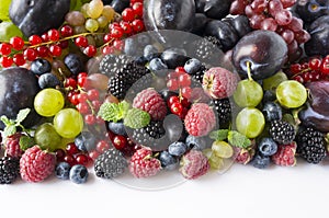 Ripe blackberries, blueberries, raspberries, red currants, plums and grapes. Mix berries and fruits. Top view. Background berries
