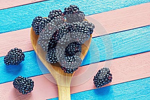 Ripe blackberries in wooden spoon. Copy space