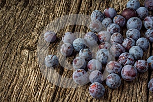 Ripe blue plums cherry plum on a dark wooden ruskic background. Top view or flat lay.