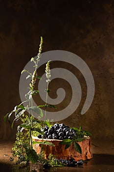 Ripe blueberries and mint on brown background