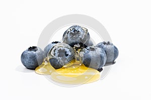Ripe blueberries on a white background drenched with honey