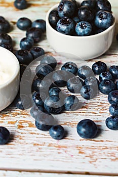 Ripe blueberries on a wooden shabby table with an estimate in a close-up