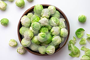 Ripe brussels sprouts its leaves lie on the table and in a wooden bowl