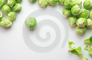 Ripe Brussels sprouts are spread out on the table, its leaves lie next to it