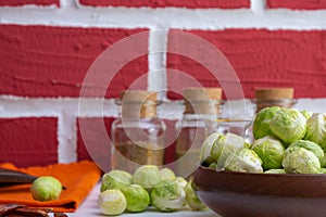 Ripe brussels sprouts in a wooden bowl and garlic, various spices, oil