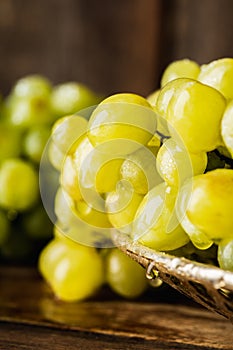 Ripe bunch of green grapes washing on vintage metal colander