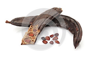 Ripe carob pod with seeds isolated on white