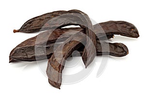 Ripe carob pod on white background