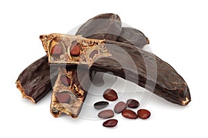 Ripe carob pods and seeds on white background