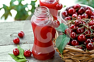 Ripe cherries in a basket and fruit juice
