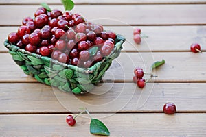 Ripe cherries in a basket on wooden table