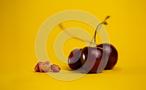 ripe cherries with pits on a yellow background