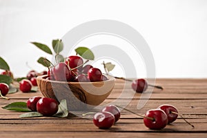 Ripe cherries in a wooden bowl on the background