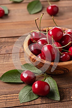 Ripe cherries in a wooden bowl on the background