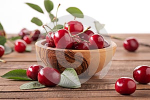 Ripe cherries in a wooden bowl on the background