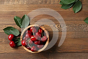 Ripe cherries in a wooden bowl on a wooden table