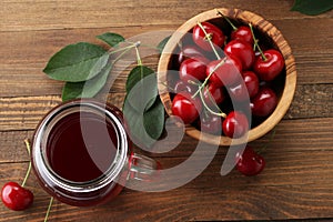 Ripe cherries in a wooden bowl on a wooden table