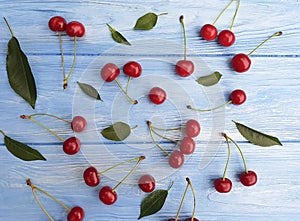 Ripe cherry berry on a blue wooden background, seasonal pattern