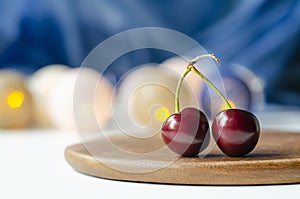 Ripe cherry close-up. Cherry sisters. Bokeh. Wood