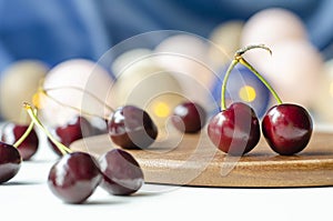 Ripe cherry close-up. Garlands are burning. Wood