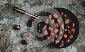 Ripe chestnuts in an old iron pan.