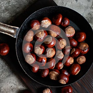 Ripe chestnuts in an old iron pan.