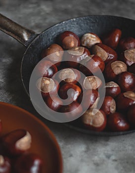 Ripe chestnuts in an old iron pan.