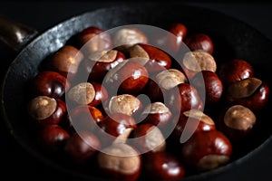 Ripe chestnuts in an old iron pan.