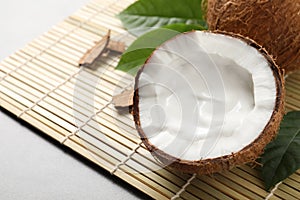 Ripe coconut with cream on bamboo mat. Space for text