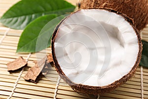 Ripe coconut with cream on bamboo mat. Space for text
