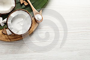 Ripe coconut and cream on white wooden table, flat lay. Space for text