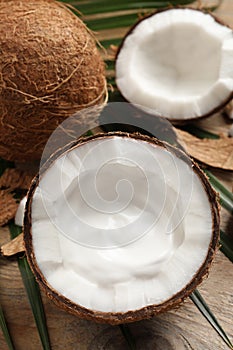 Ripe coconut with cream on wooden table, above view