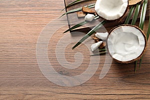 Ripe coconut with cream on wooden table, above view. Space for text