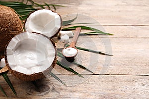 Ripe coconut and cream on wooden table. Space for text