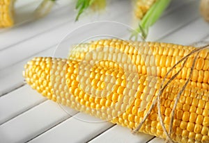 Ripe corn cobs on wooden background, closeup