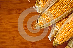 Ripe corn cobs on a wooden table