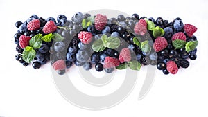 Ripe currants, blackberries, blueberries and raspberries with mint leaves. Mix fruits and berries isolated on white background wit