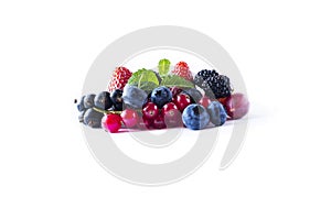 Ripe currants, blackberries, blueberries and strawberries with mint. Fruits and berries isolated on white background. Sweet and ju