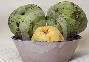 Ripe custard apples and quince on a rustic plate photo