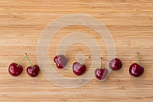 Ripe dark red stella cherries on bamboo chopping board with copy space above