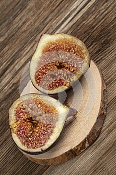 Ripe fig fruit cut in half on a wooden table