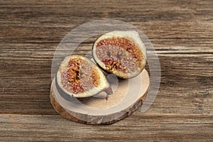 Ripe fig fruit cut in half on a wooden table