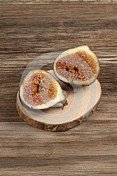 Ripe fig fruit cut in half on a wooden table