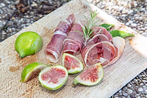 Ripe fig fruits and bacon or prosciutto. Food to accompany the d