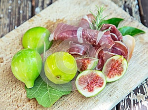 Ripe fig fruits and bacon or prosciutto. Food to accompany the drinks