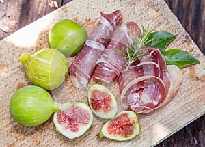 Ripe fig fruits and bacon or prosciutto. Food to accompany the drinks