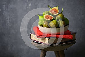 Ripe figs heap on book and old wooden stool