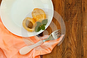 Ripe fresh apricot fruits on a white plate on the wooden background. Copy space, delisious healthy food